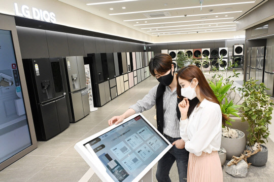 LG 베스트샵 무인매장에서 고객들이 키오스크를 활용해 제품 정보를 확인하고 있다. <LG전자 제공>